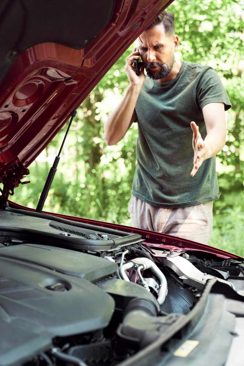 Junger Mann prüft Getriebeschaden bei Schrottauto Ankauf Velbert